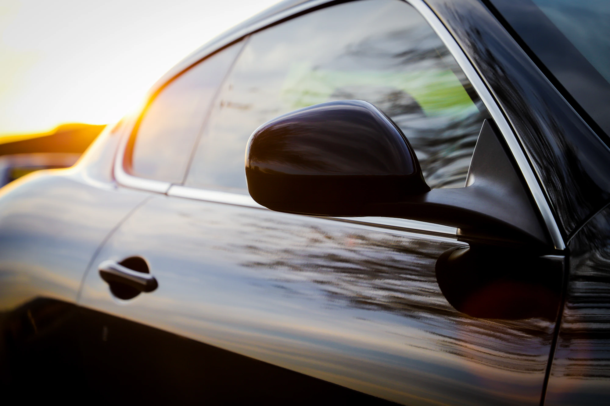Auto negro con acabado brillante al atardecer